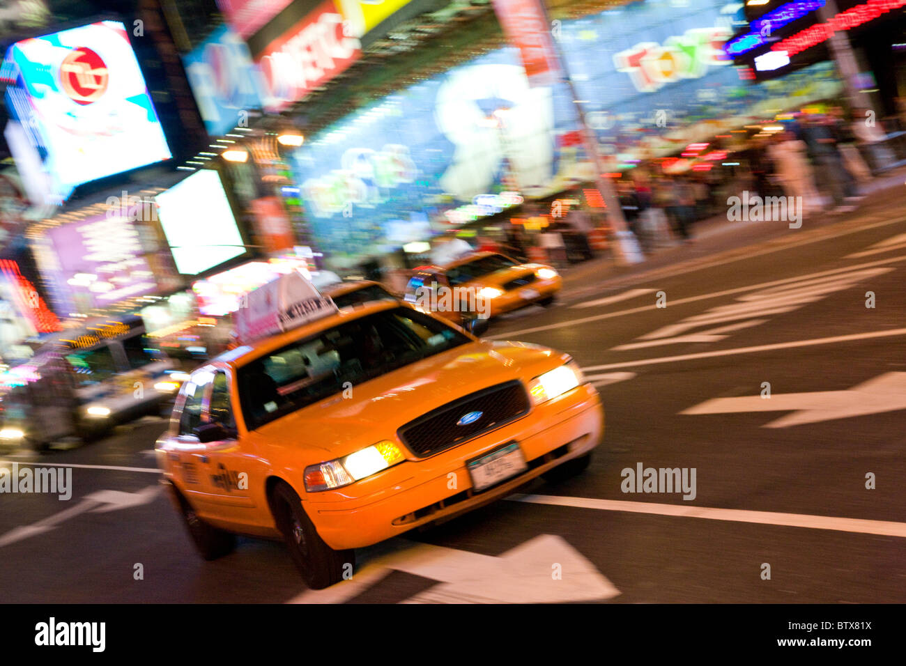 Yellow taxi cab at night in Times Square, New York Stock Photo