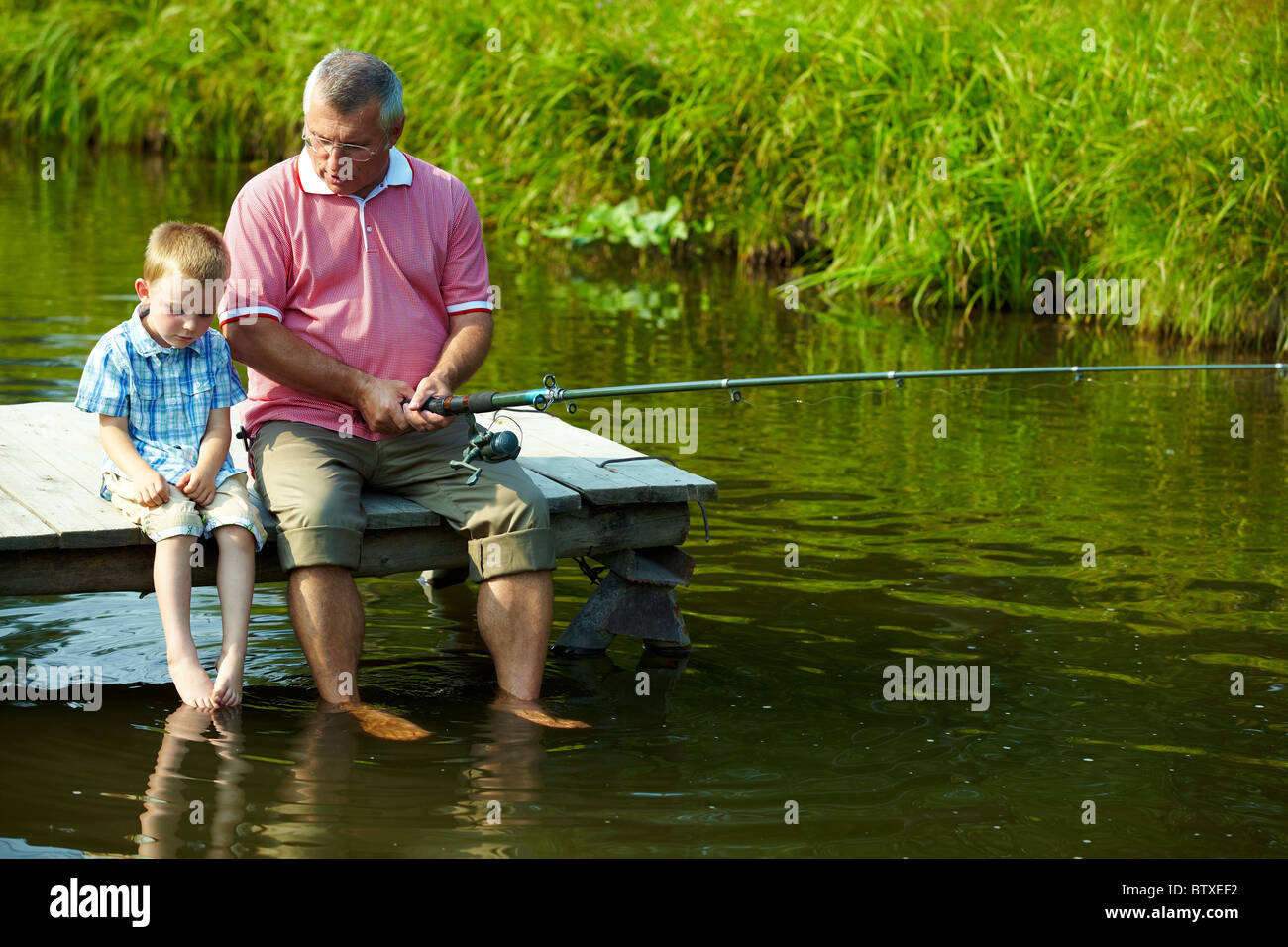 Дедушка ловит рыбу. Дедушка рыбачит с внуком. Дед с внуком на рыбалке. Дедушка у реки.