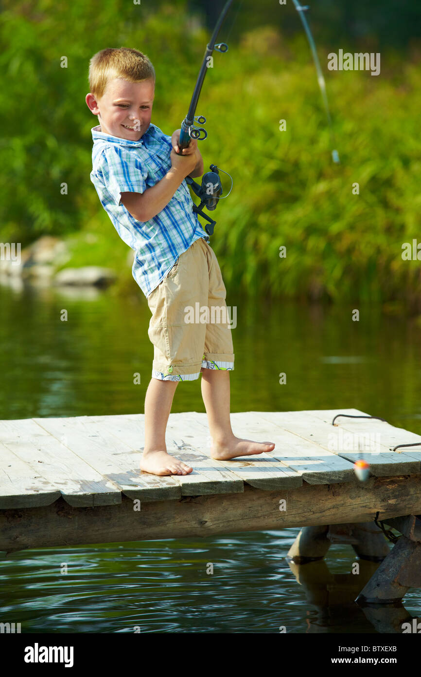 Photo of little kid pulling rod while fishing on weekend Stock