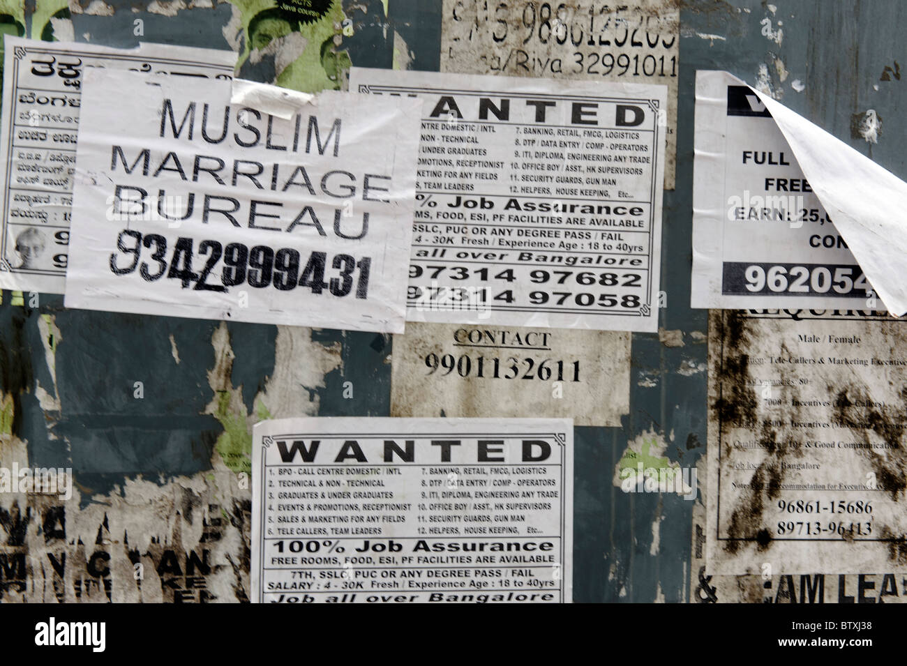 Posters on a Bangalore wall including a marriage bureau Stock Photo Alamy