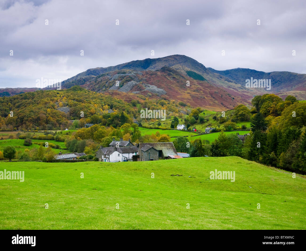 The hamlet of Little Langdale with Wetherlam and Great Intake in the distance in the Lake District National Park. Cumbria, England. Stock Photo