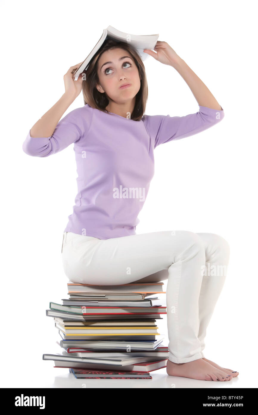 Smiling woman sitting on stack of books Stock Photo - Alamy
