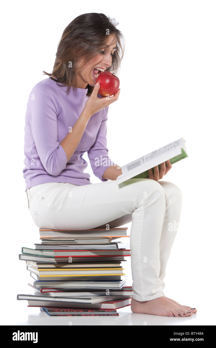 Smiling woman sitting on stack of books Stock Photo - Alamy