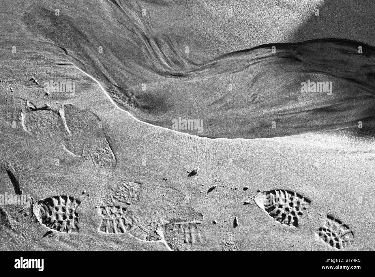 Footsteps on the sandy beach in black and white Stock Photo
