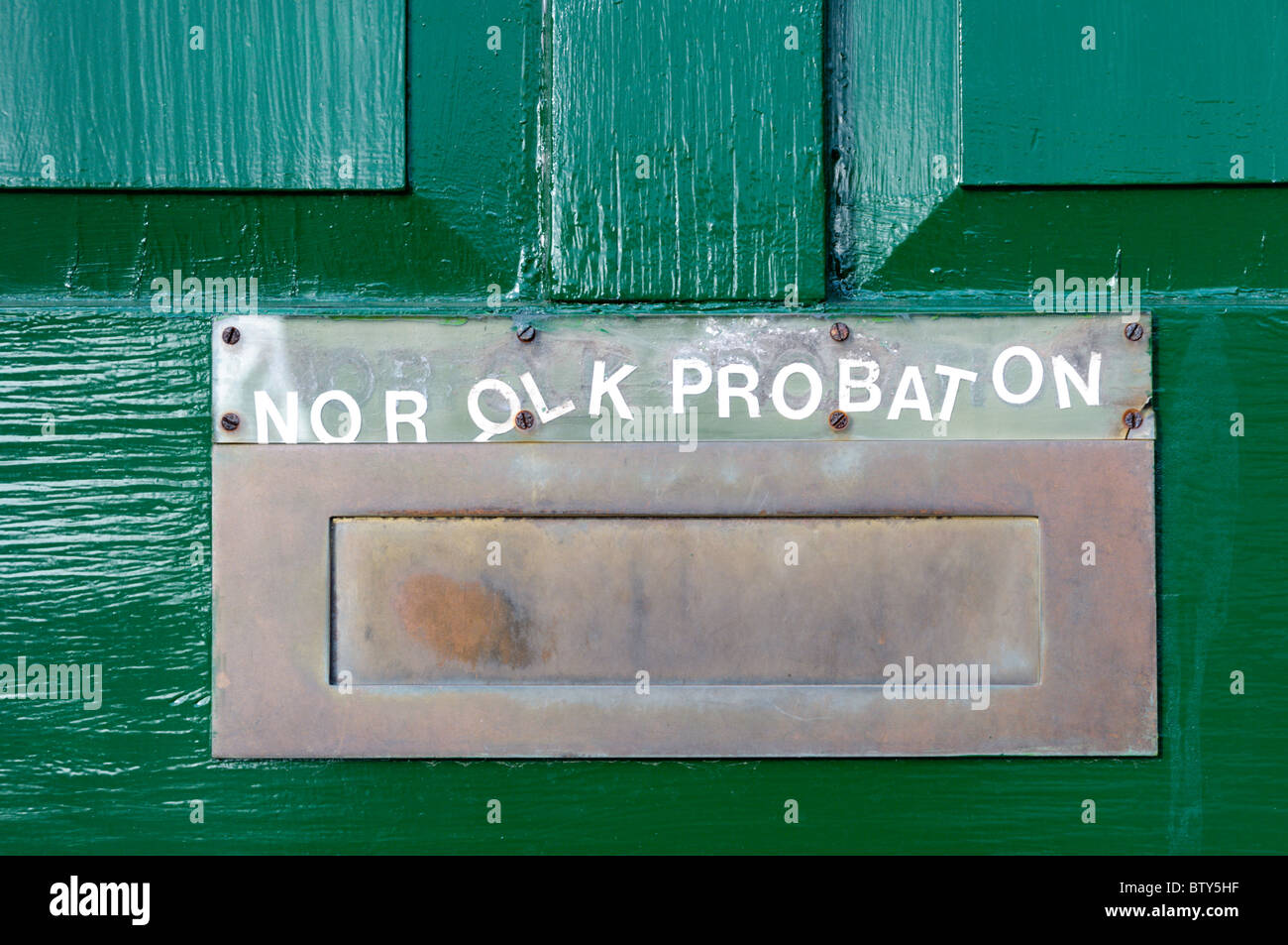 Uneven and missing lettering on a sign for the Norfolk Probation Service letterbox Stock Photo
