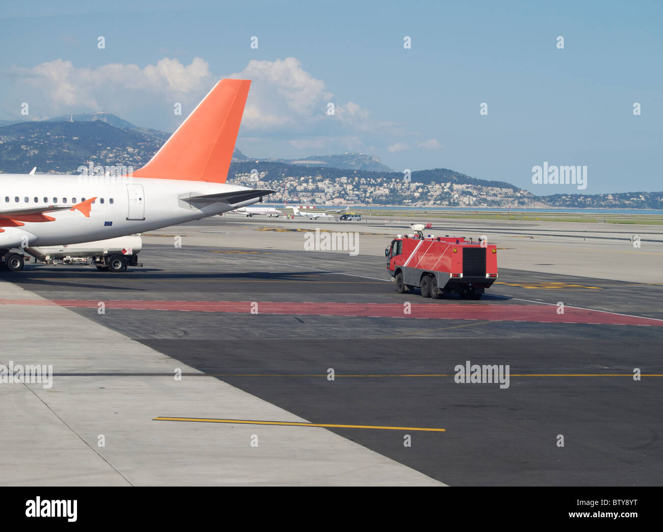Fire tender standing by aircraft refueling at Nice Airport. Cote d'Azur. France Stock Photo