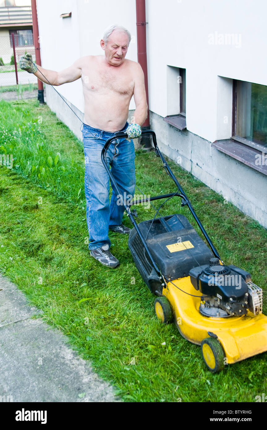 man cutting the grass with the mower Stock Photo - Alamy