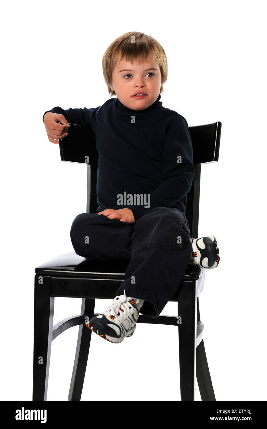 Child with Down Syndrome sitting on chair isolated over white