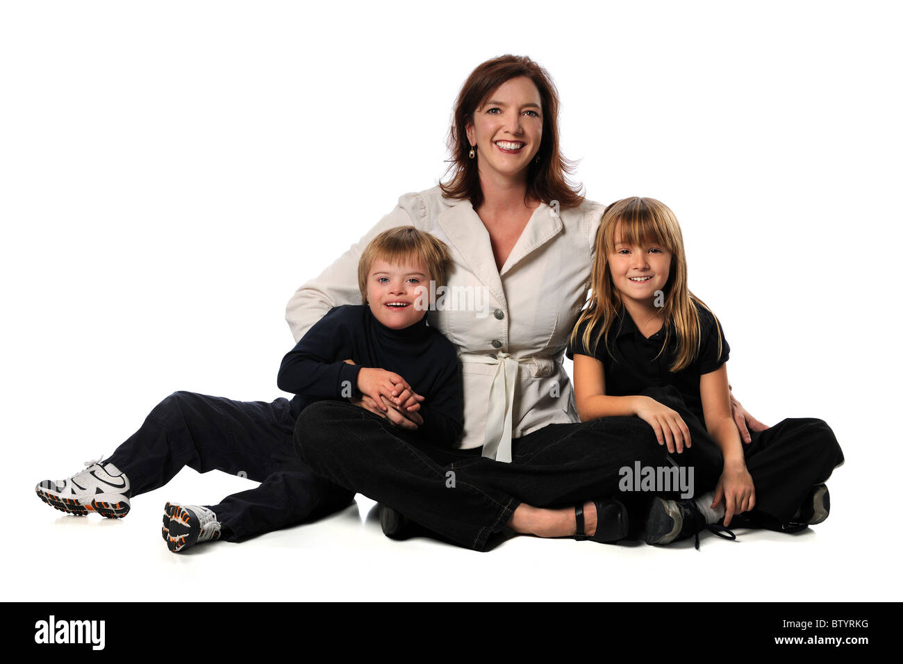 Mother, daughter and son with Down Syndrome sitting isolated over white background Stock Photo