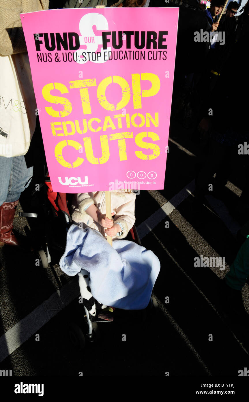 UK CHILD ON BUGGY AT STUDENTS RALLY AGAINST EDUCATION SPENDING CUTS IN LONDON Stock Photo