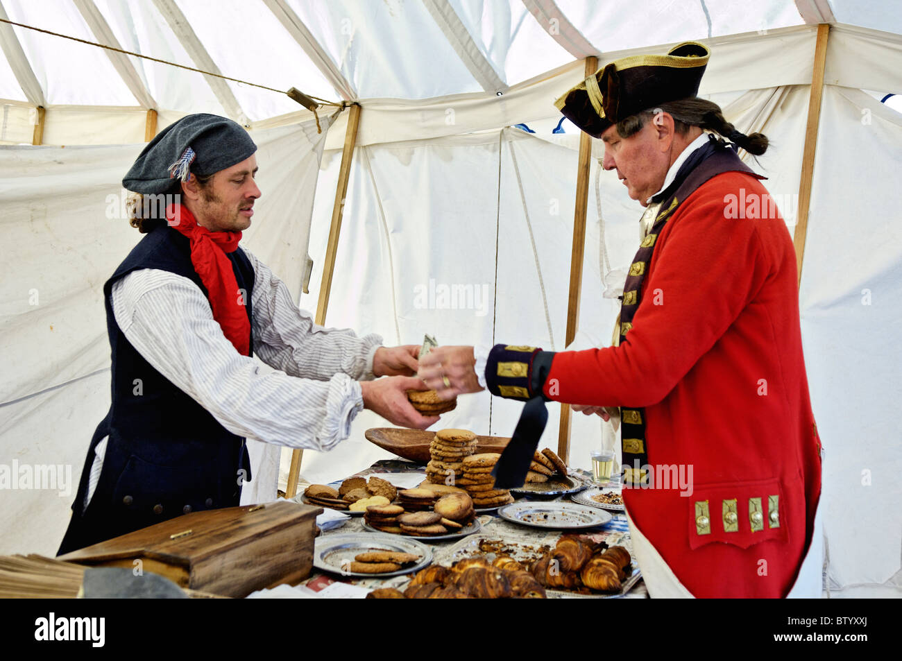 British Revolutionary War Soldier Buying Baked Goods from Baker in Period Costume at Locust Grove in Louisville, Kentucky Stock Photo