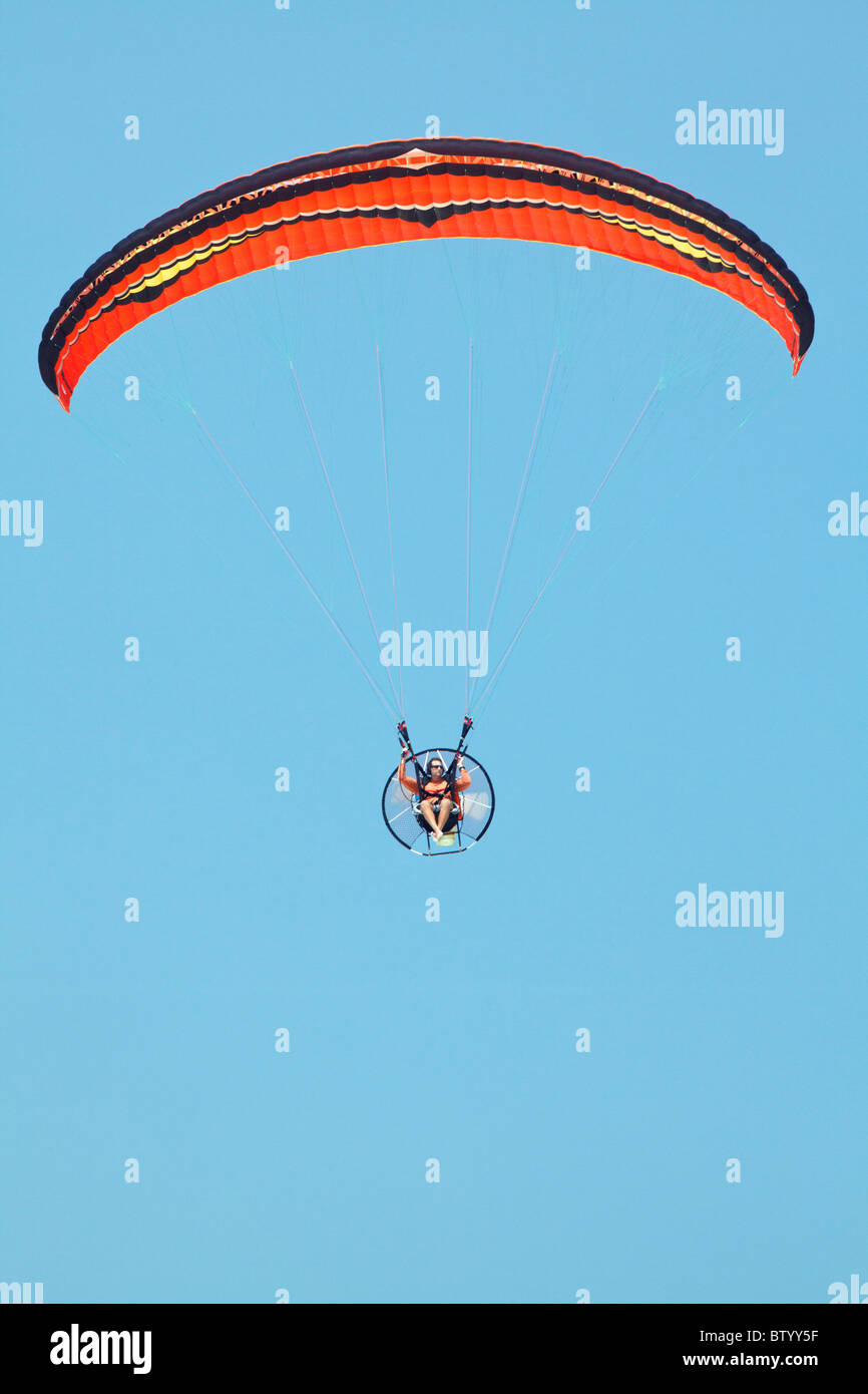 A powered para glider and wing, flying in a clear blue sky Stock Photo Alamy