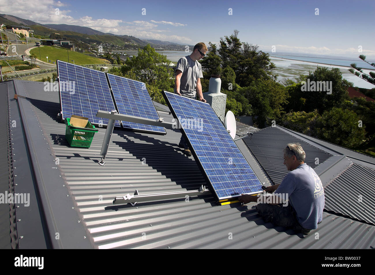 Photovoltaic solar panels being fitted by tradesmen to a house in