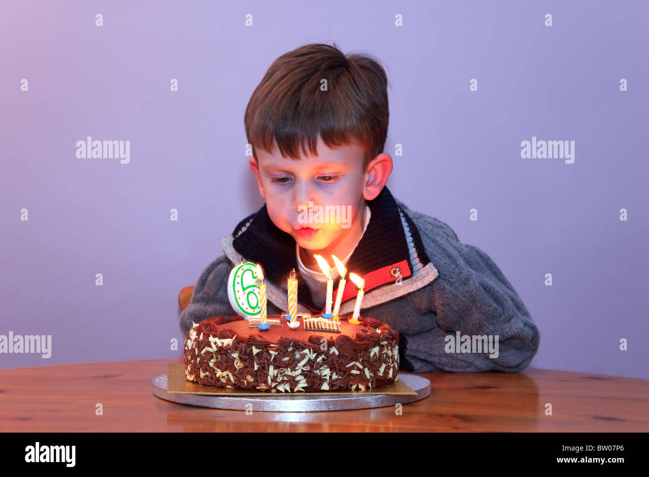 A 6 Year Old Boy Blowing Out The Candles On His Birthday Cake Stock Photo Alamy