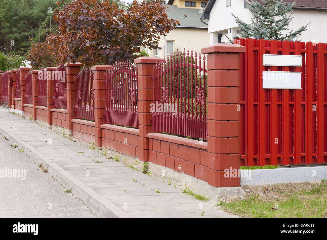 The red fence is located in rural street Stock Photo