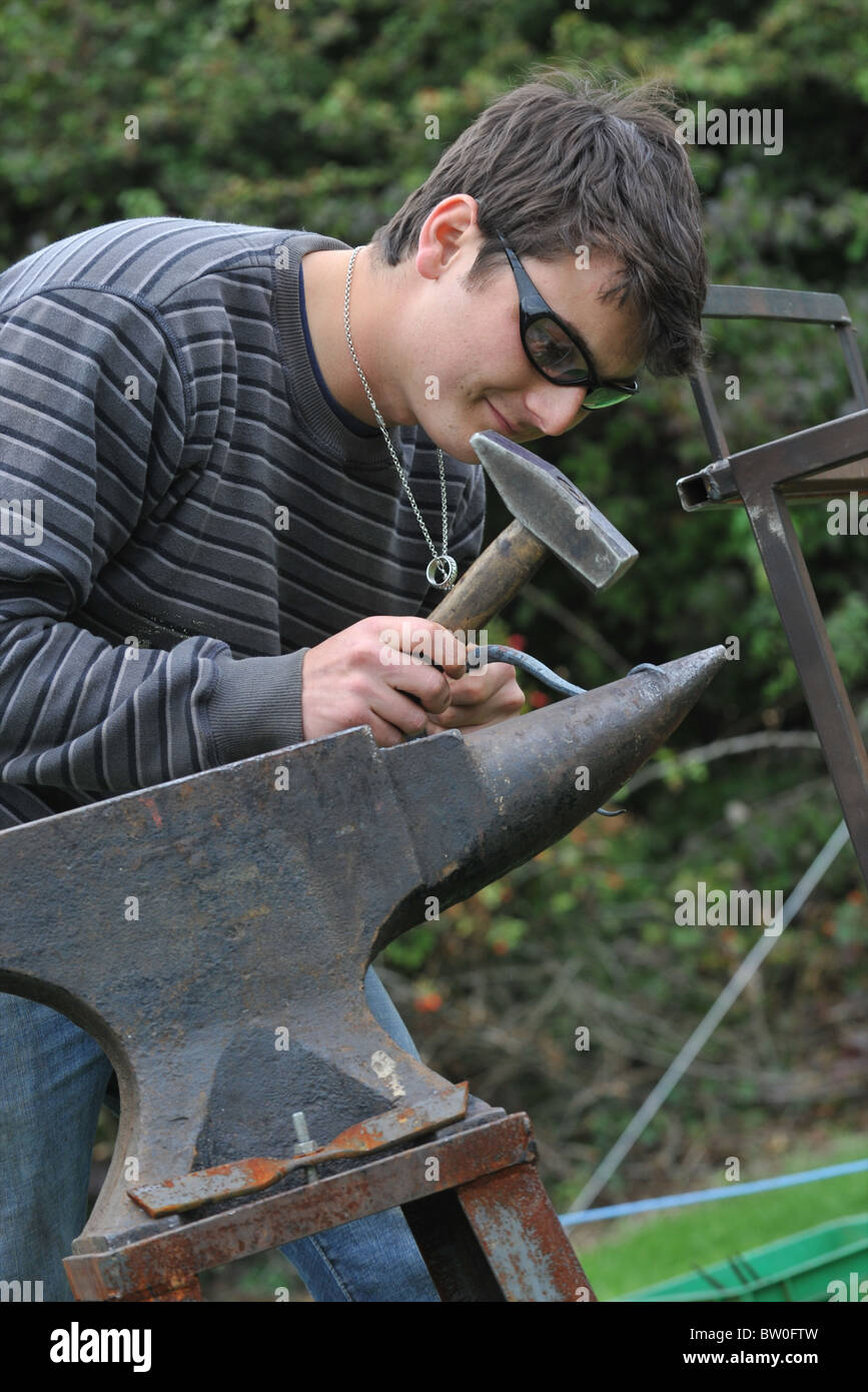 Black smith shapes metal on anvil Stock Photo