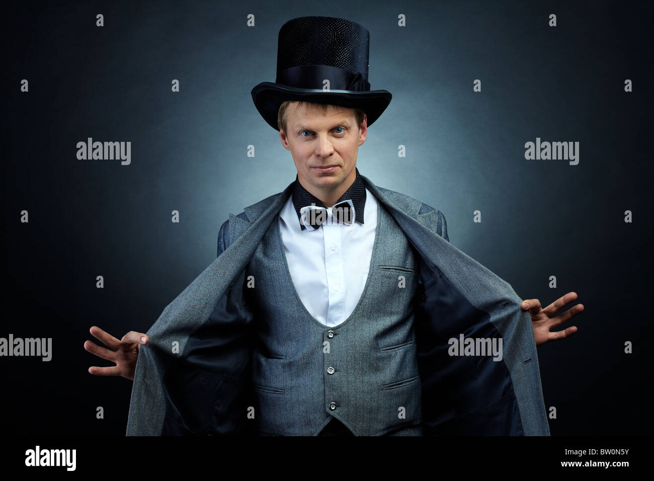 Image of male magician in hat and tail-coat looking at camera Stock Photo