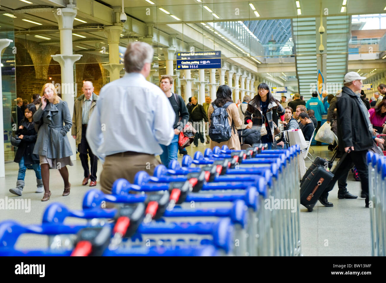 St Pancras Station , crowds of people or travelers walking by luggage