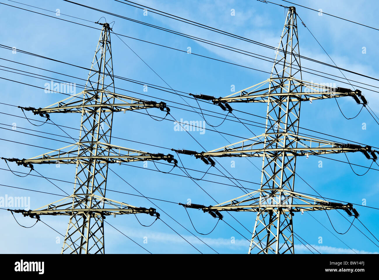 two high voltage towers against a blue sky with clouds Stock Photo - Alamy