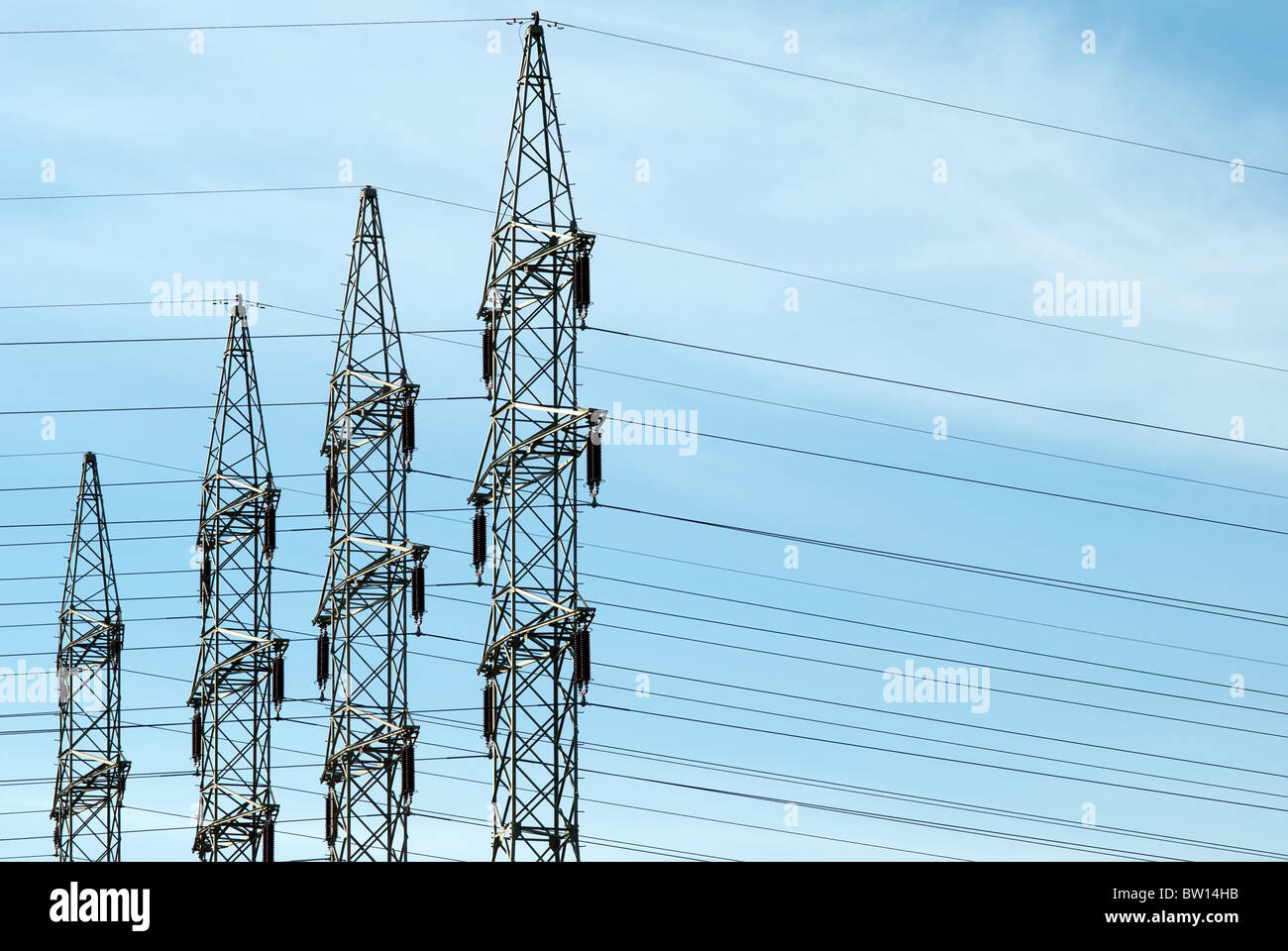 four high voltage towers against a blue sky Stock Photo - Alamy
