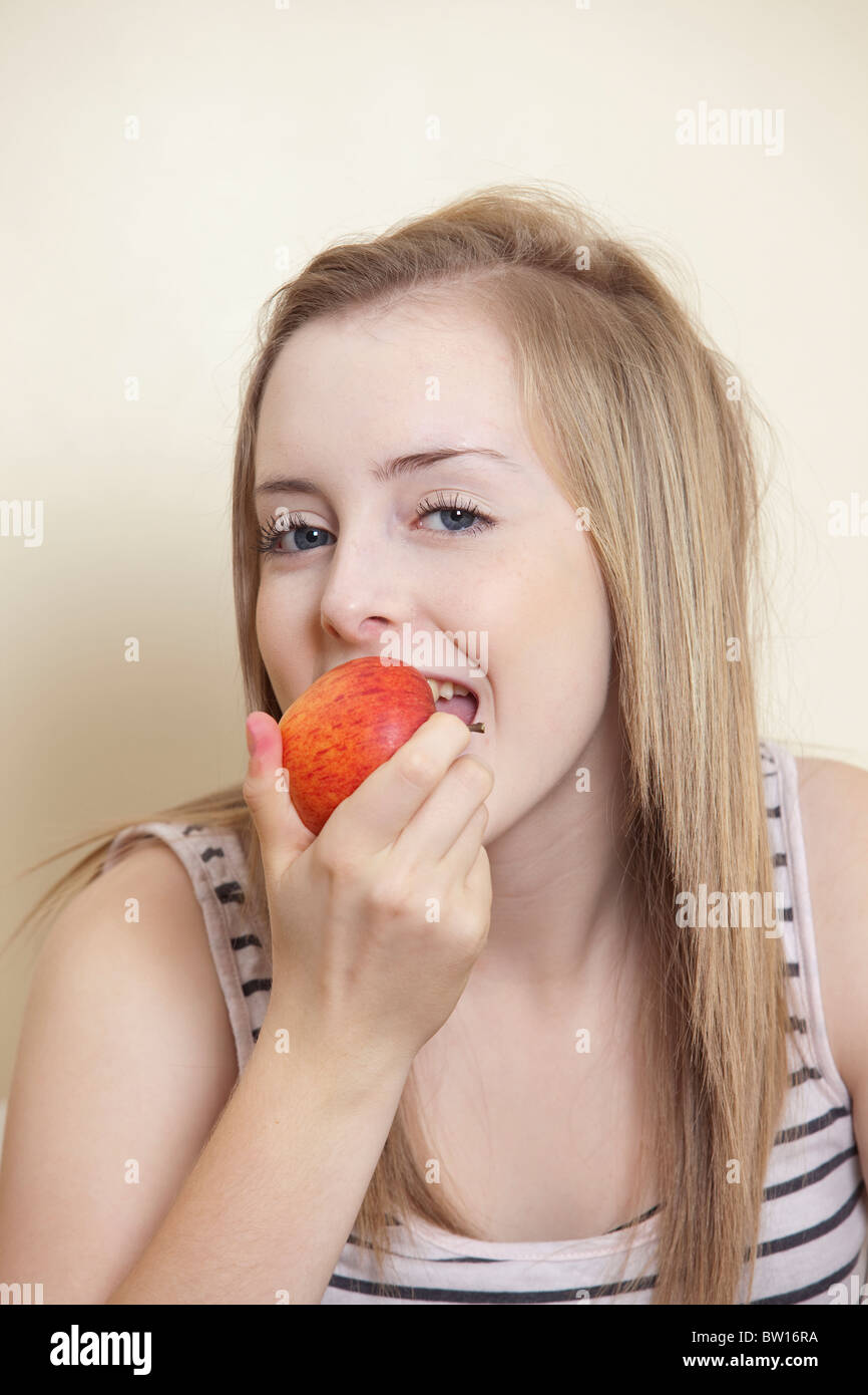 A teenage girl eats an apple UK Stock Photo