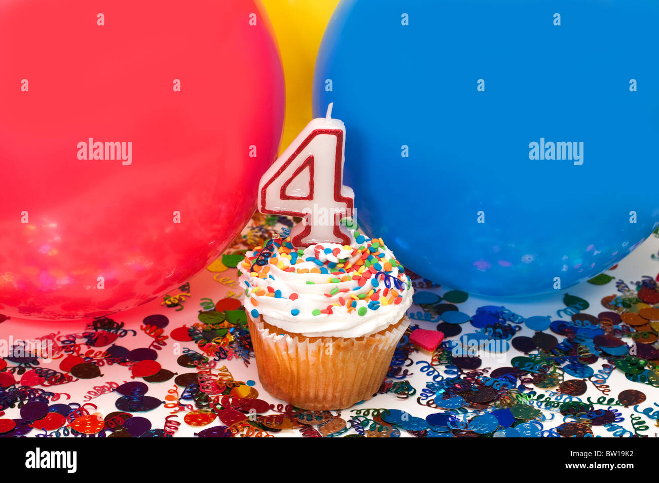 Celebration with balloons, confetti, cupcake, and number 4 candle Stock