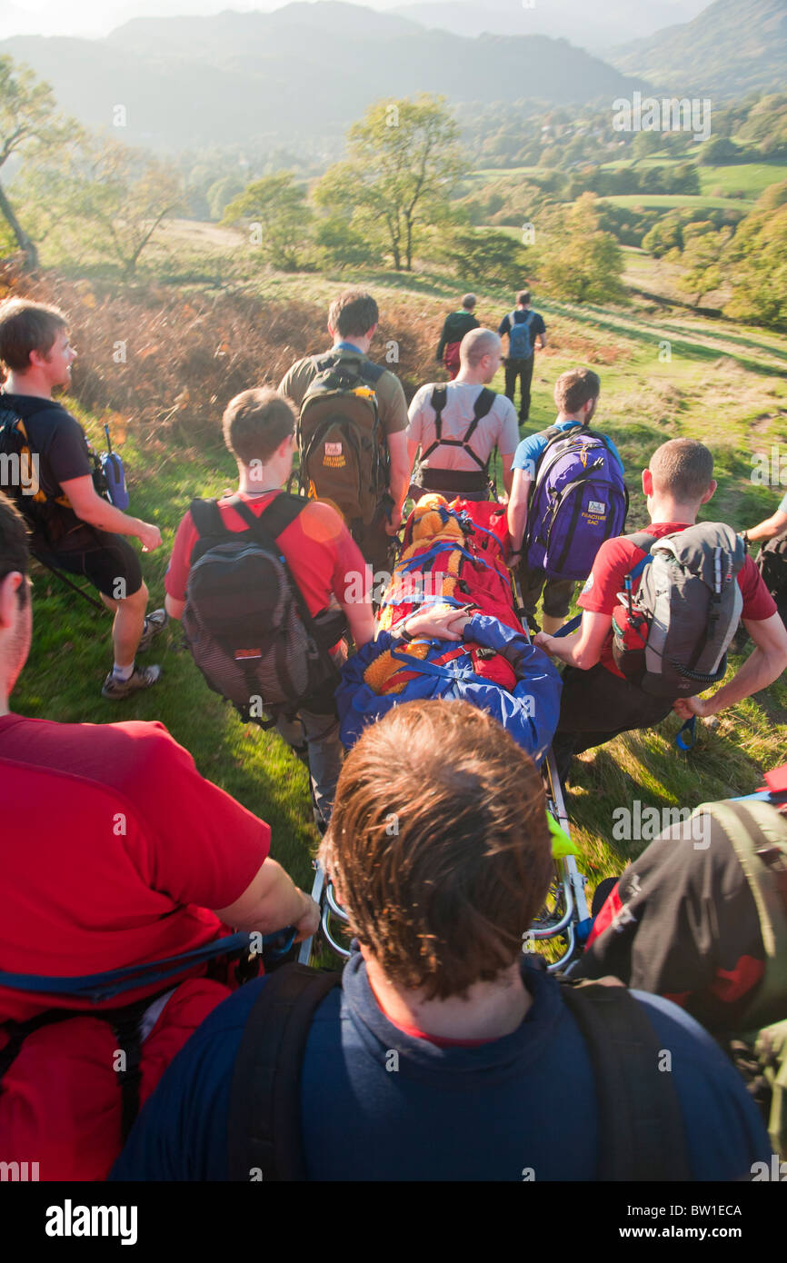 Members of the Langdale Ambleside Mountain Rescue Team evacuate an injured walker off Wansfell on a stretcher Stock Photo