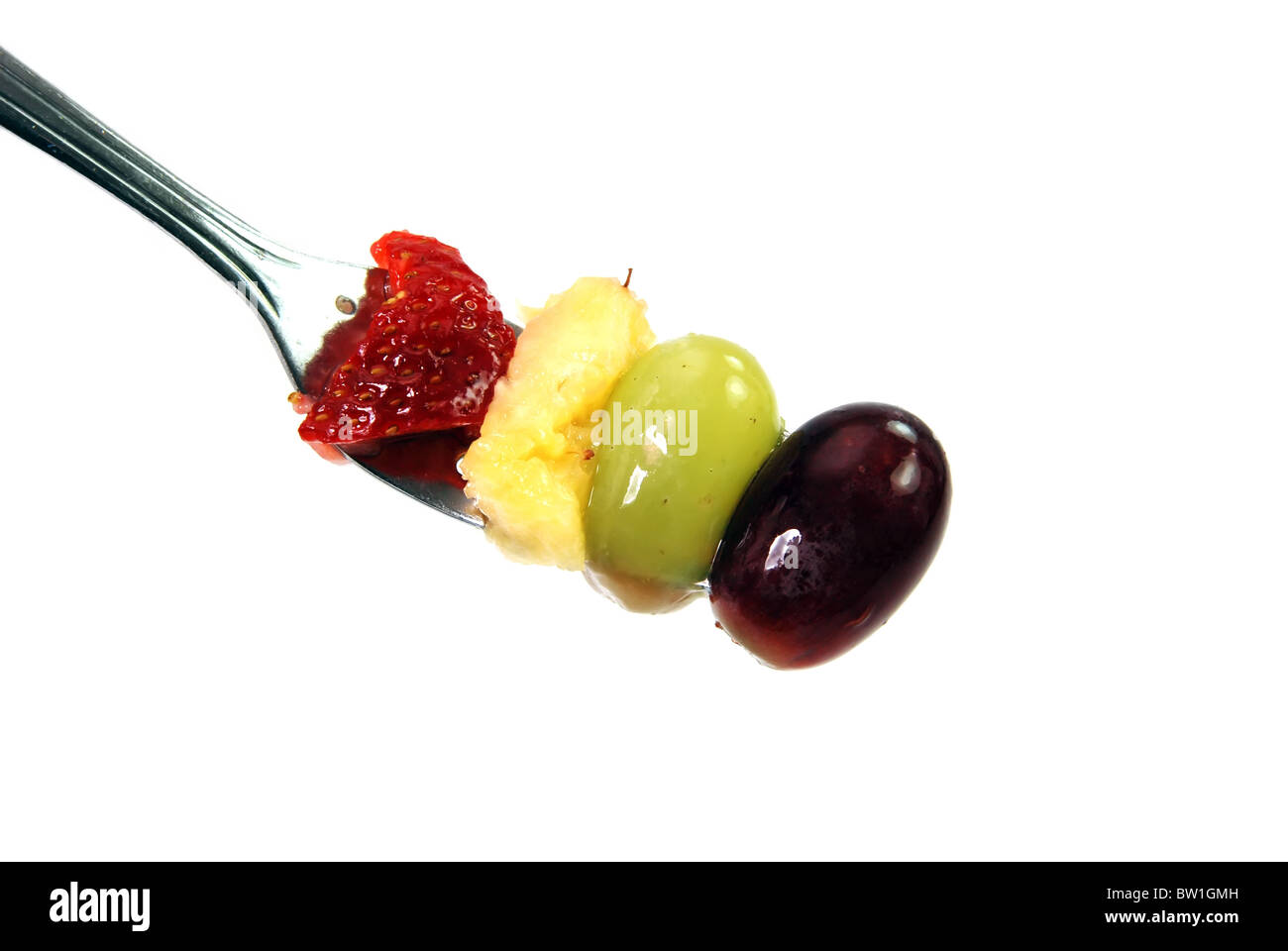 Assorted fruit on fork isolated on white background.  Antioxidants Stock Photo