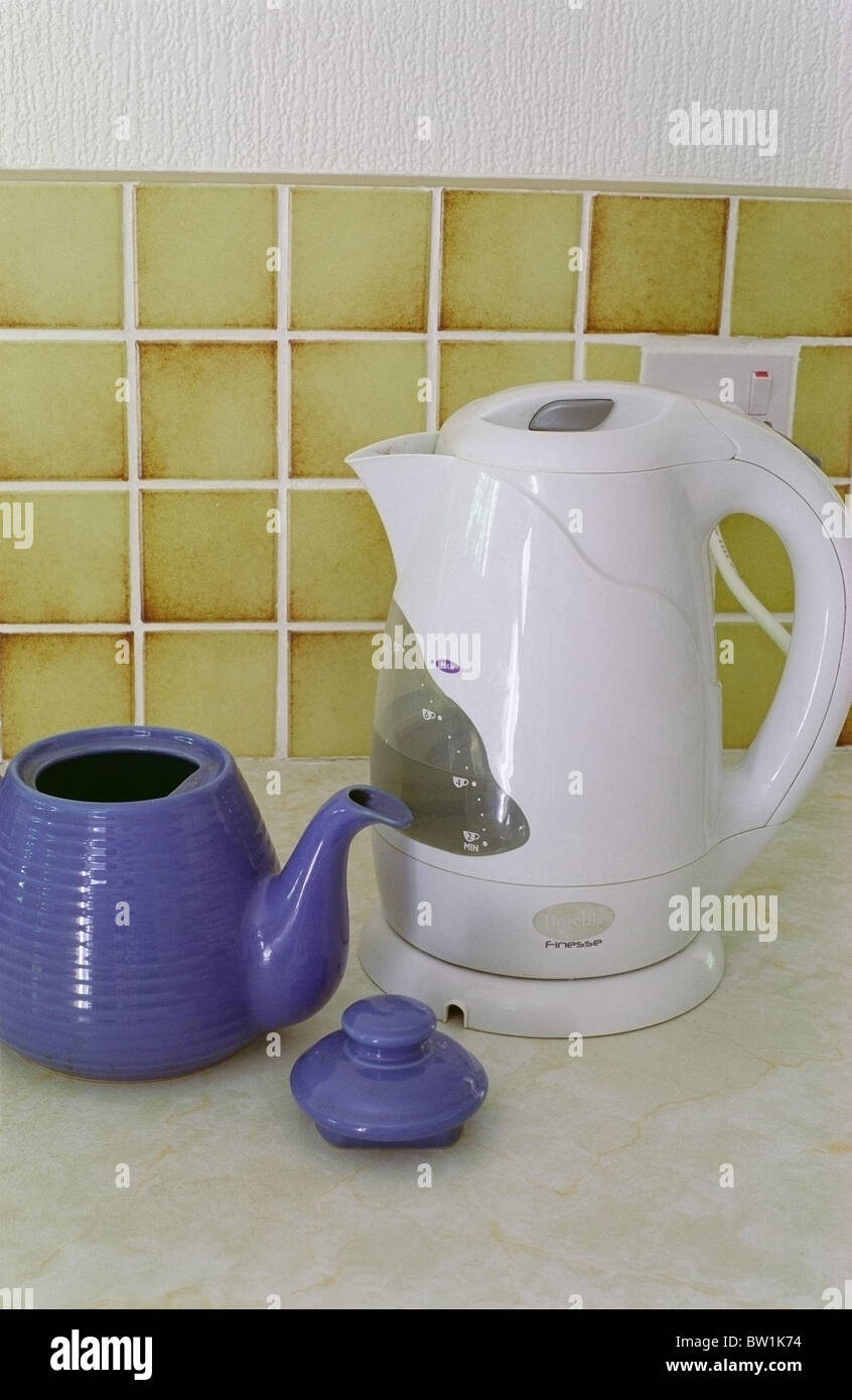 Electric Cordless White Plastic Kettle and Blue Ceramic Teapot on a Kitchen Worksurface Stock