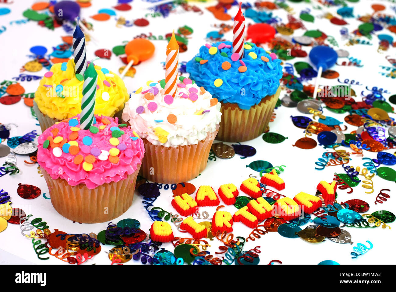 Birthday cupcakes with candles and sprinkles. Confetti and suckers in