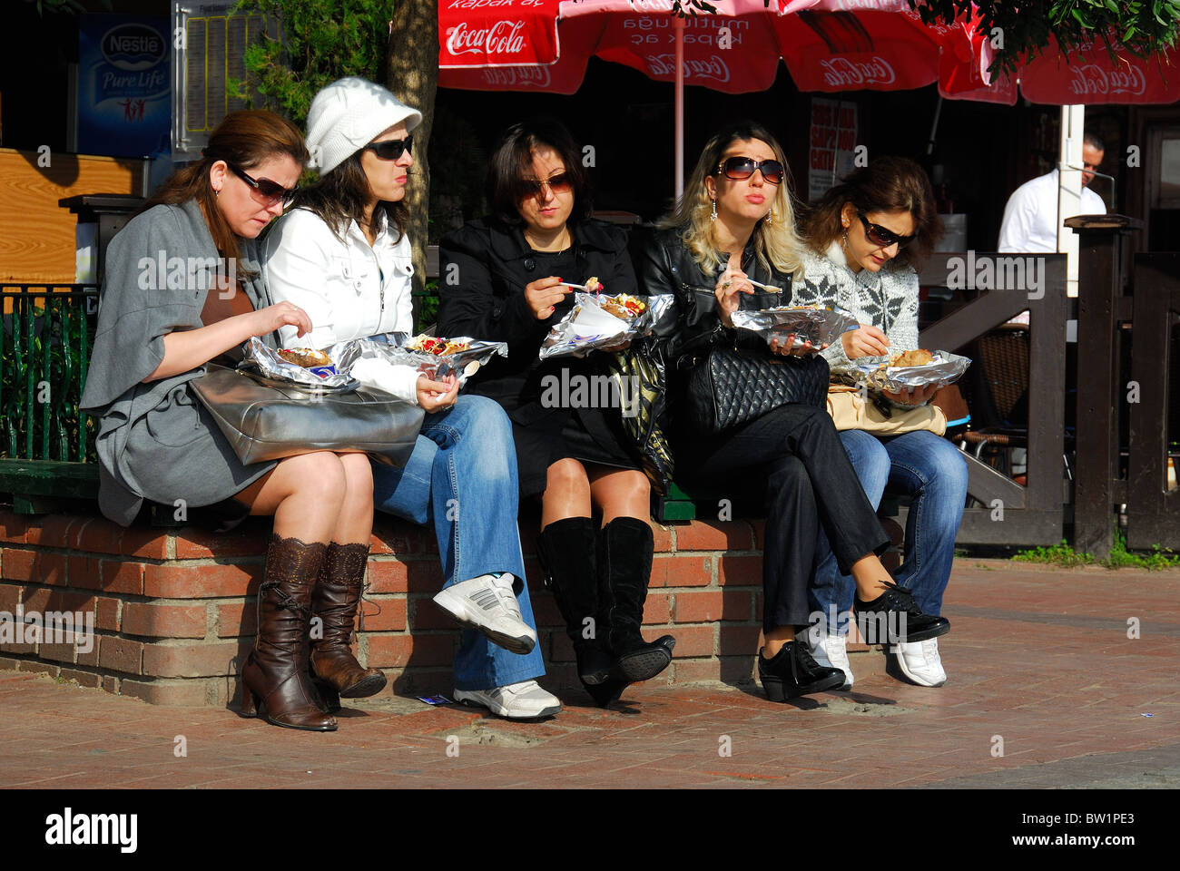 ISTANBUL, TURKEY. Five women eating kumpir (filled baked potatoes) at Ortakoy market, Besiktas district. 2010. Stock Photo