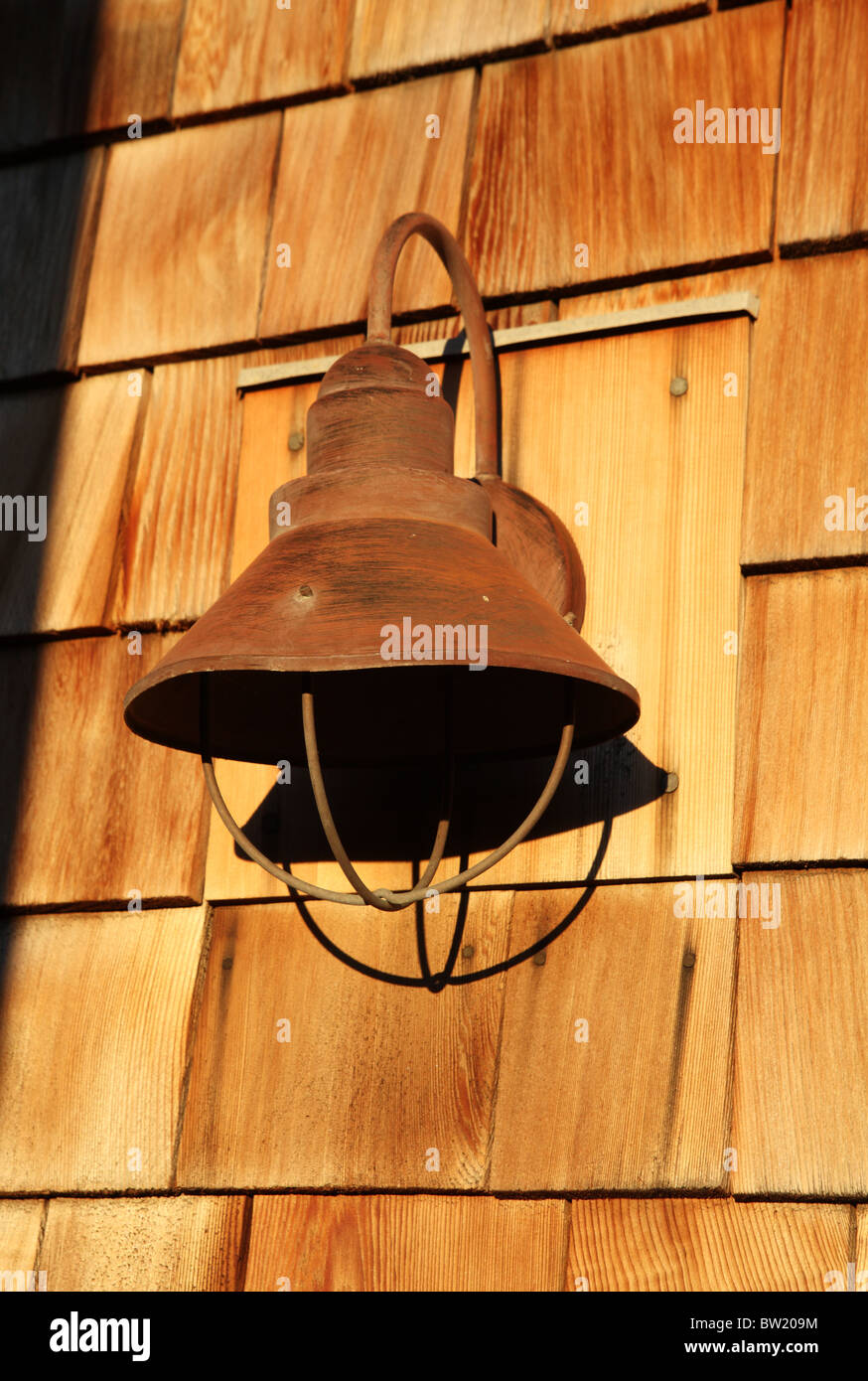 A rusted light shade on a shingle covered wall, Kennebunkport, Maine, USA Stock Photo