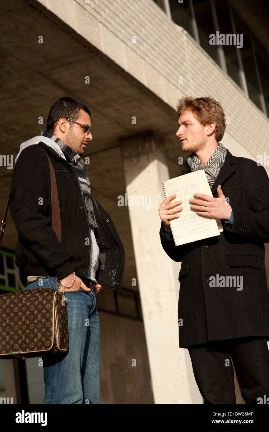 Two male students talking on the campus of Aberystwyth University Wales UK Stock Photo