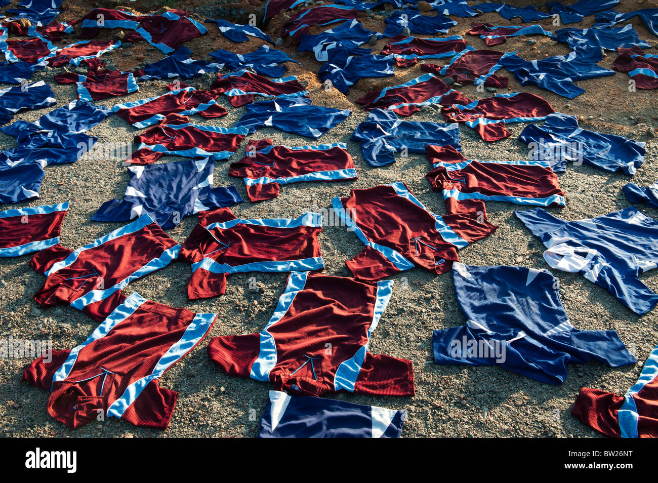 Sports shirts in the sun drying on an Indian riverbank. Andhra Pradesh, India Stock Photo