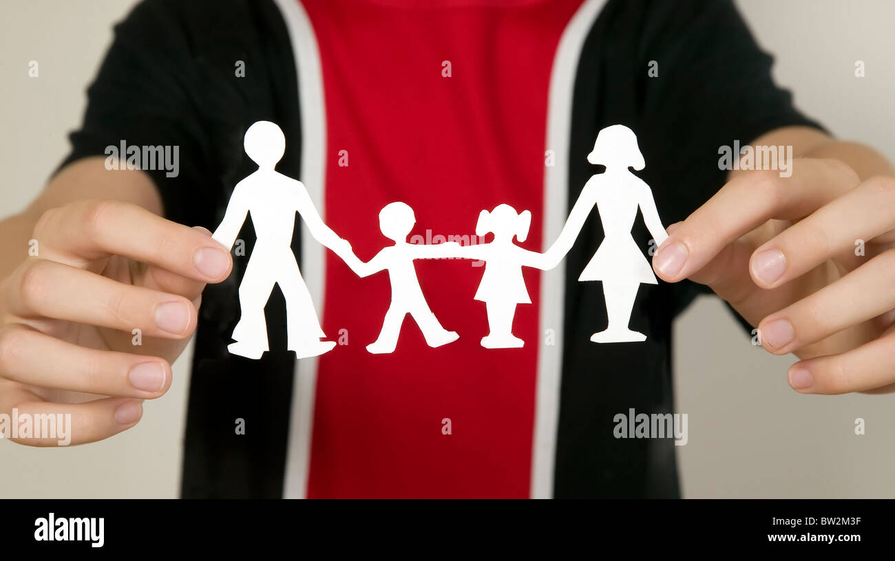Child with black and red shirts is holding family figures made from paper Stock Photo