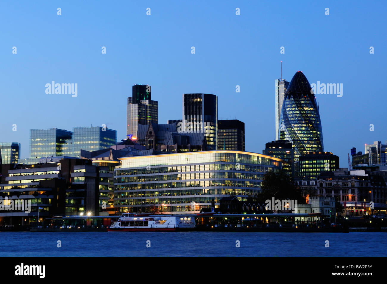City of London buildings and Tower Pier at dusk, London, England, UK Stock Photo