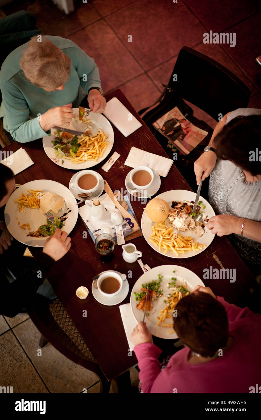 Overhead view of a group of four people eating lunch dinner meal at SALT cafe bar restaurant Aberystwyth Wales UK Stock Photo