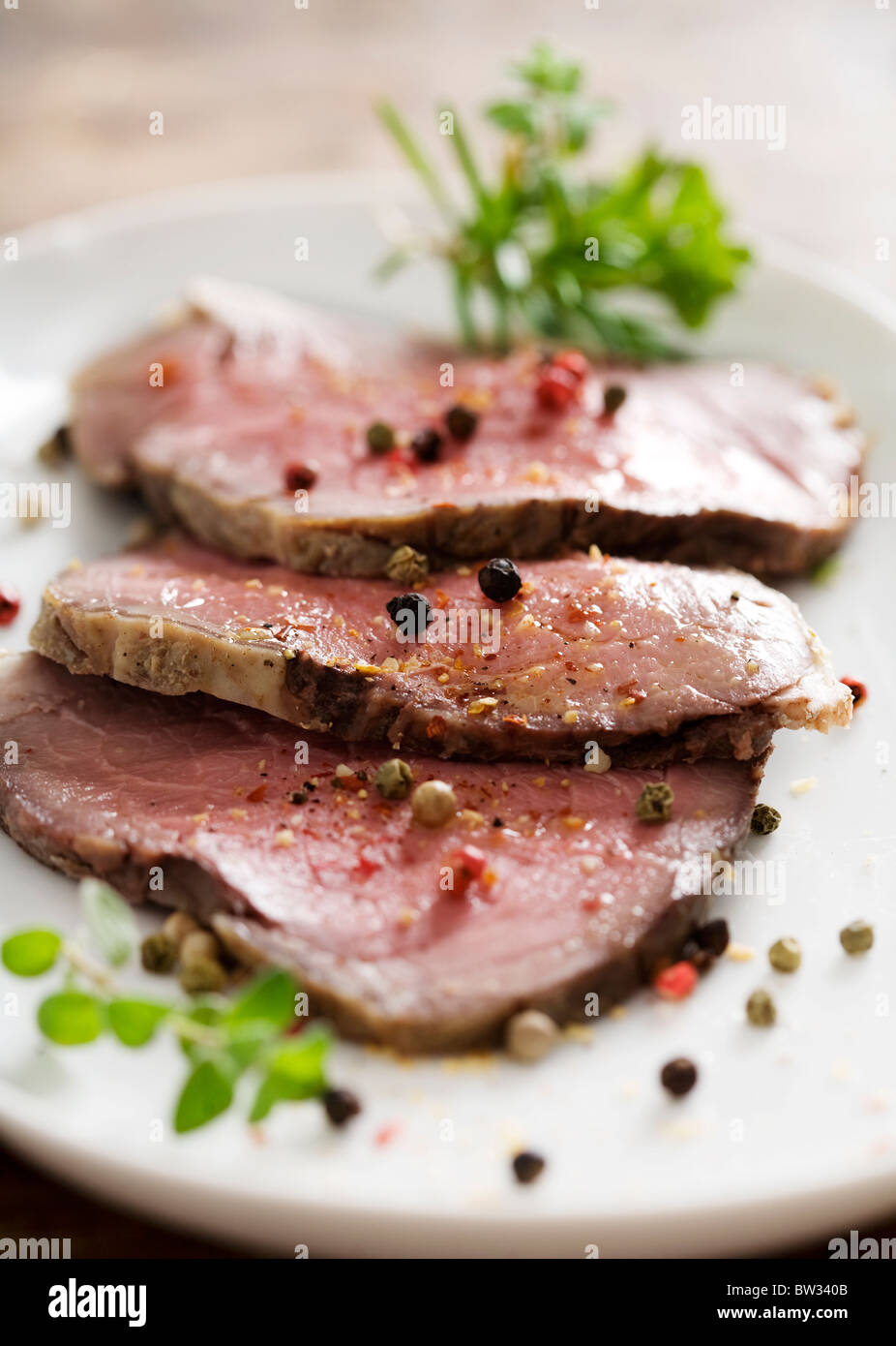 slices of juicy roast beef with herbs and pepper Stock Photo Alamy