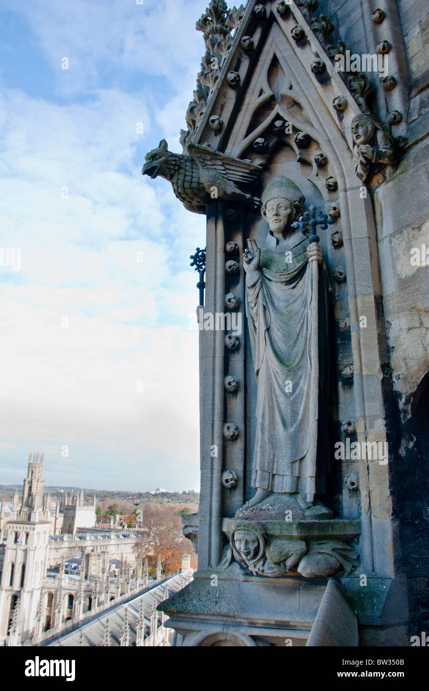 Carved ornament high above on the spire of the church of St Mary the Virgin with All Souls College down below, Oxford, UK Stock Photo