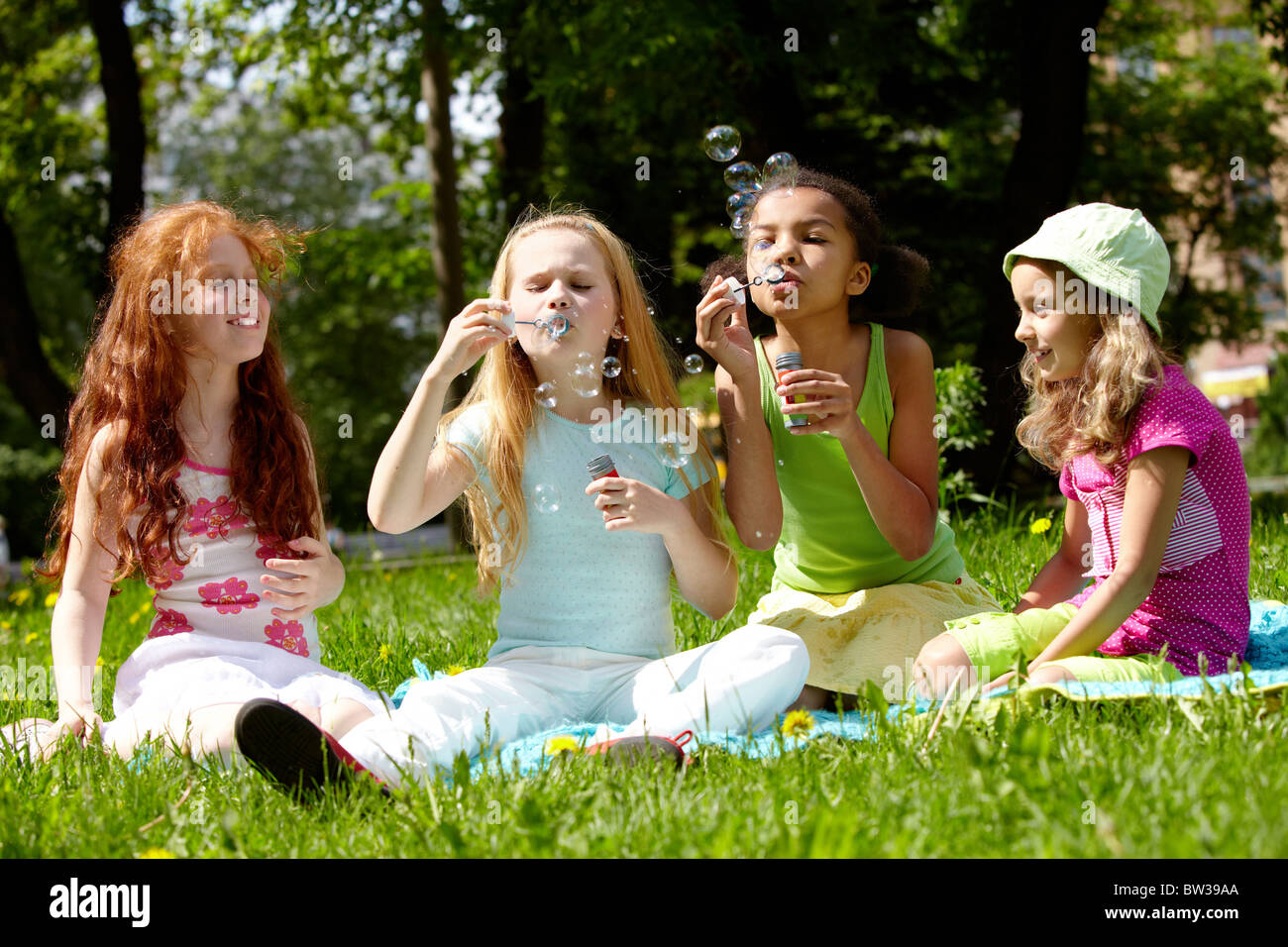 Portrait of cute girls playing on green lawn in park Stock Photo - Alamy