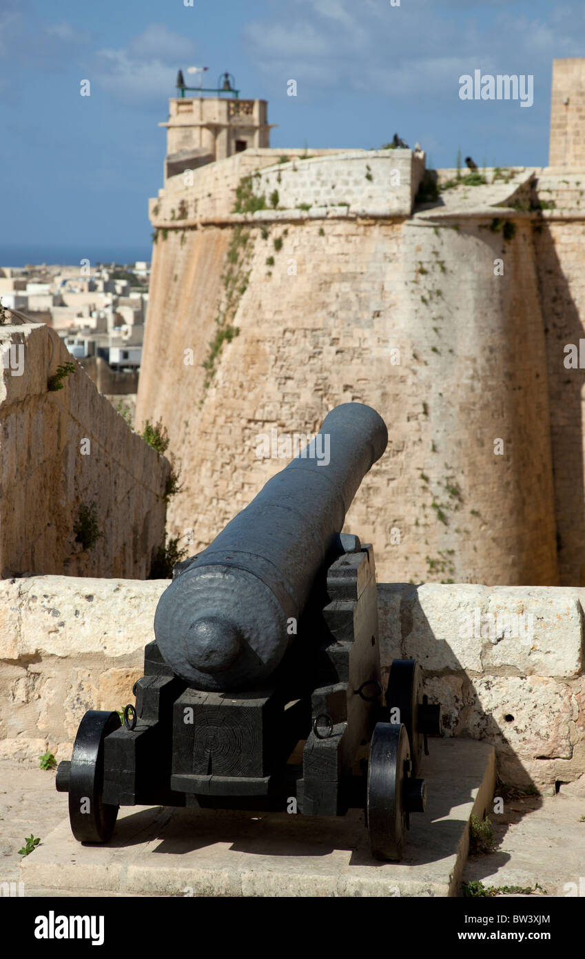 A cannon poking through a battlement at a dramatic fold in the fortifications at the Citadel in Gozo in Malta. Stock Photo