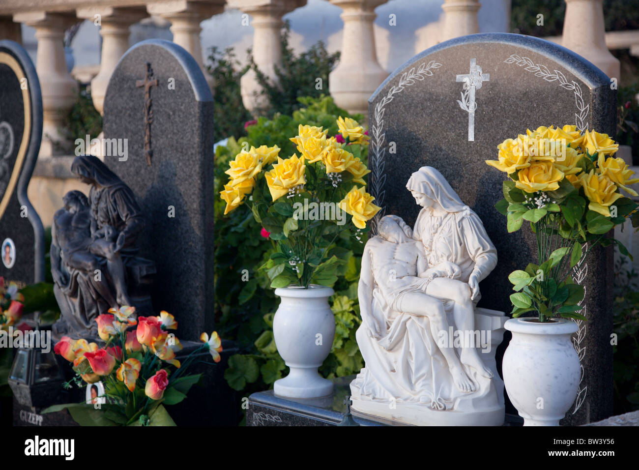 Ornate baroque tombstones adorn graves in cemeteries in the Maltese Islands. Stock Photo