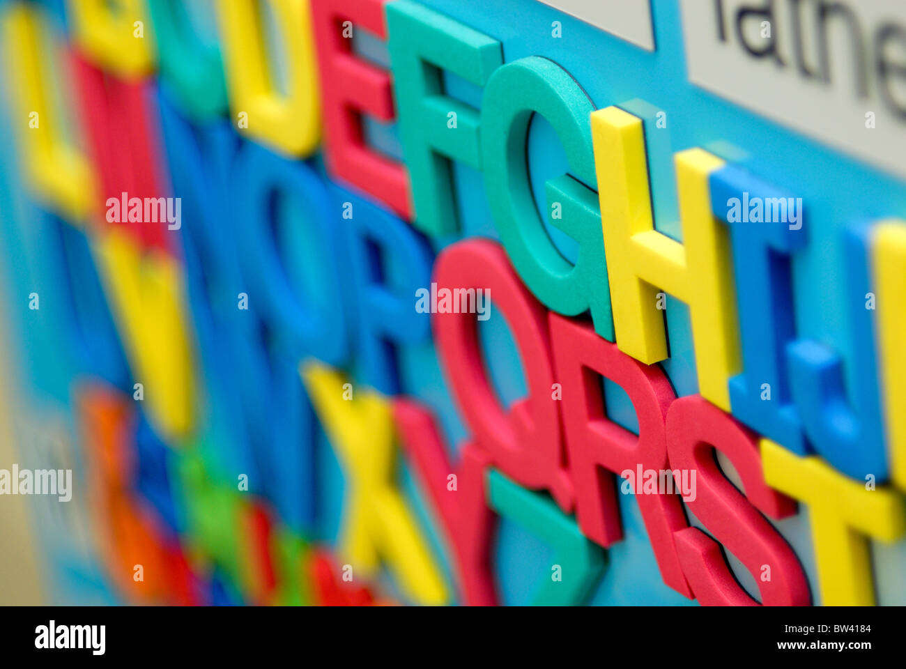 Multicolored refrigerator magnets that are letters of the alphabet are aligned. Stock Photo