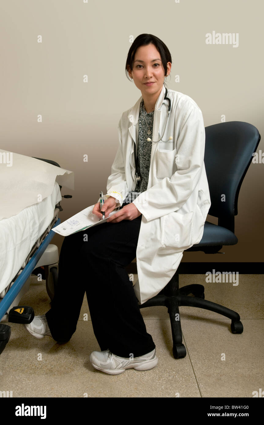 Female doctor beside hospital bed with patients' chart in hospital