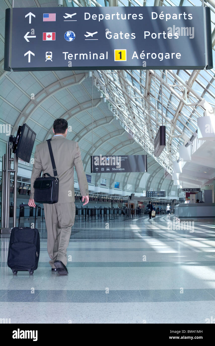Businessman walking through airport with travel bag, Toronto, Ontario, Canada Stock Photo