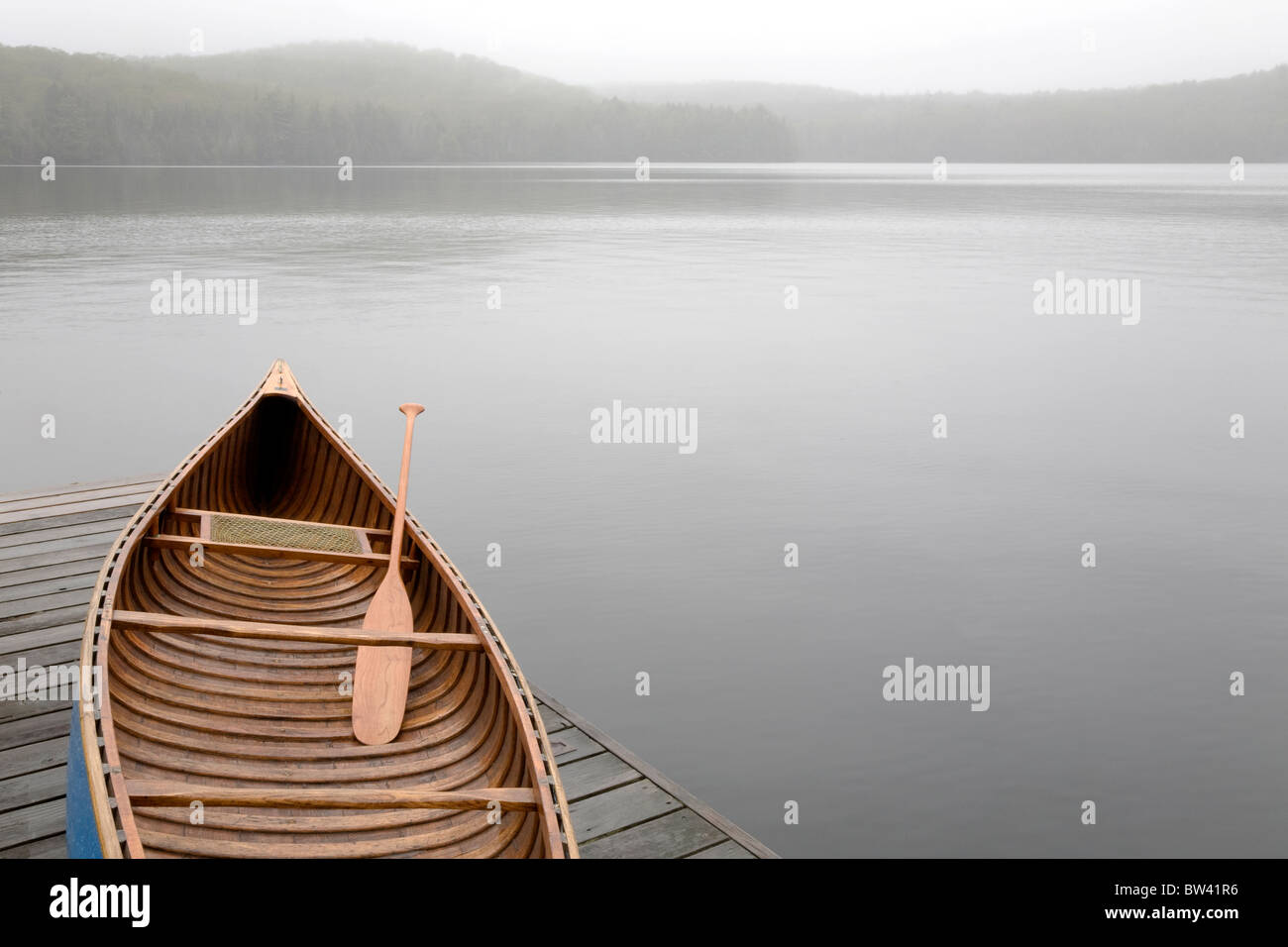 Canoe on cottage dock on a misty morning, Algonquin Park, Ontario Stock Photo