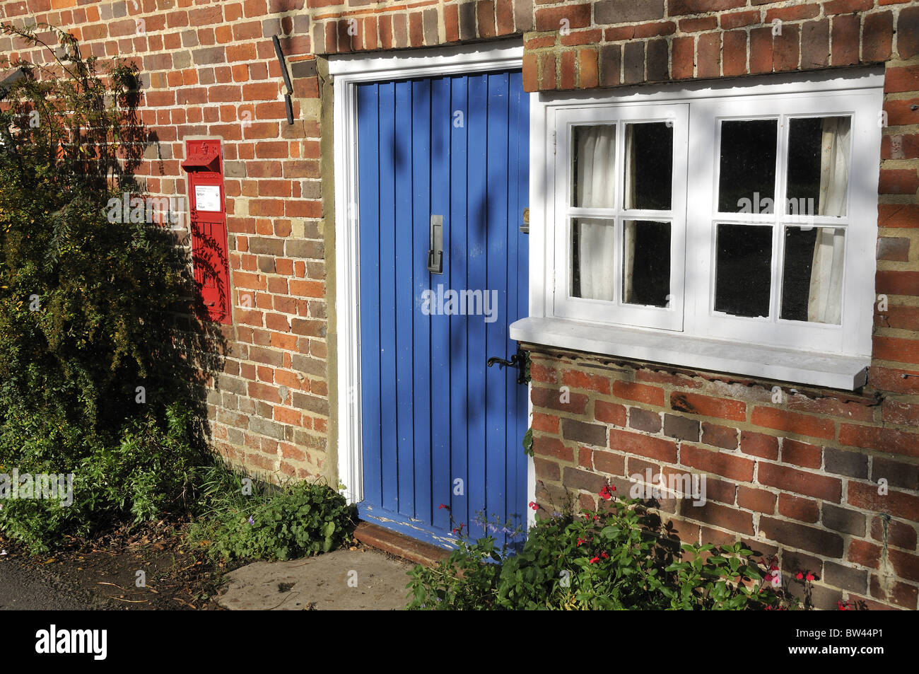 Blue Front Door And Old Post Box Set In Brick Wall Of
