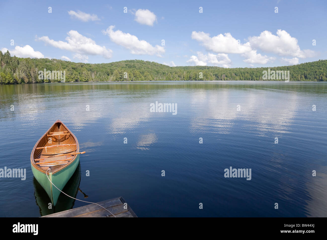 Green canoe tied to cottage dock, Algonquin Park, Ontario Stock Photo