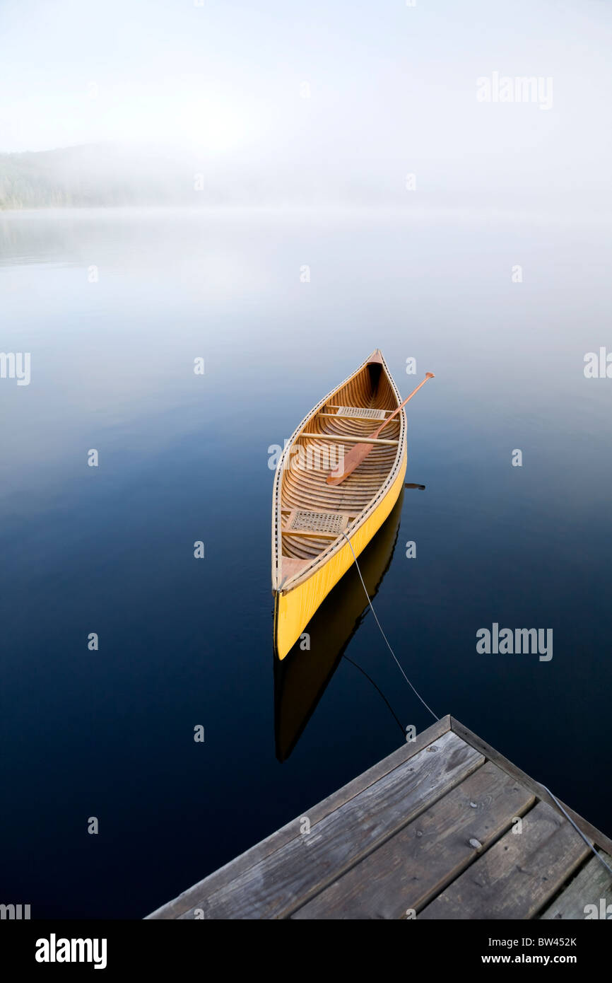 Yellow canoe tied to cottage dock, Algonquin Park, Ontario Stock Photo