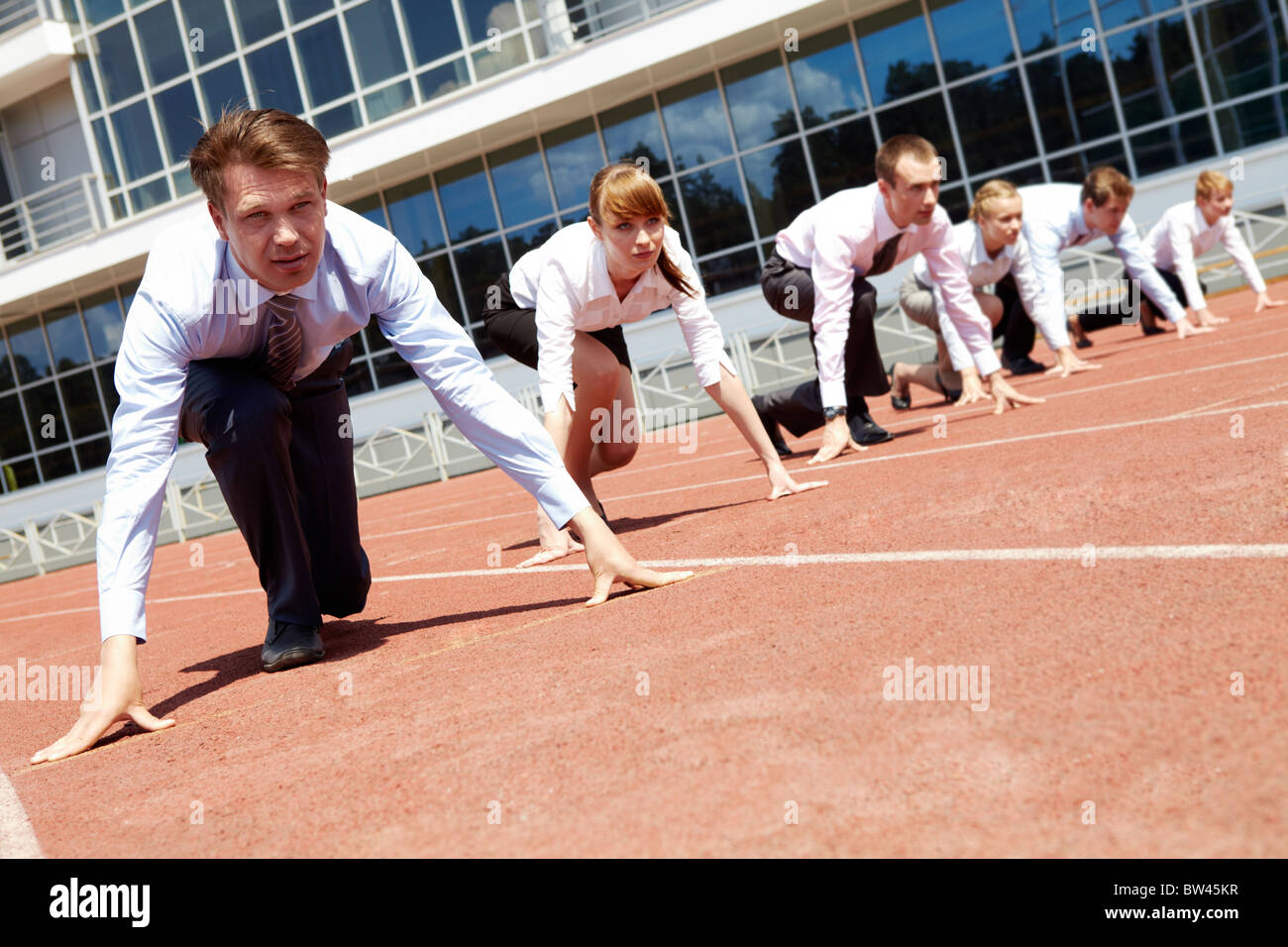 Confident business people lined up getting ready for race Stock Photo